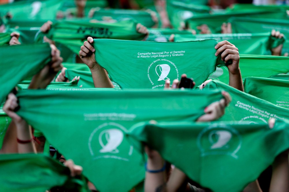 Manifestantes levantando sus pañuelos verdes durante una manifestación frente al Congreso argentino